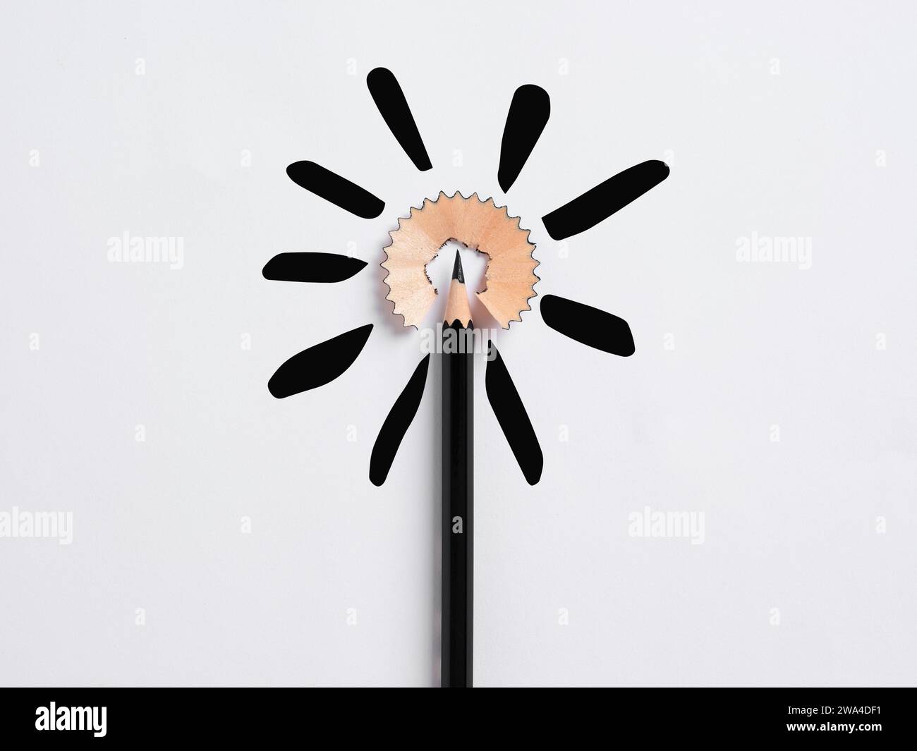 Education concept. Black pencil tip surrounded by its shaving representing a flower shape on white background. Stock Photo