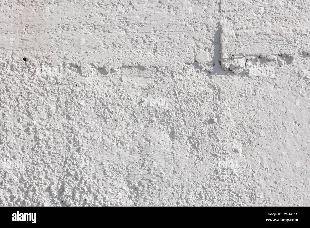 rough whitewash or white plaster wall under direct sunlight, full-frame background and texture Stock Photo