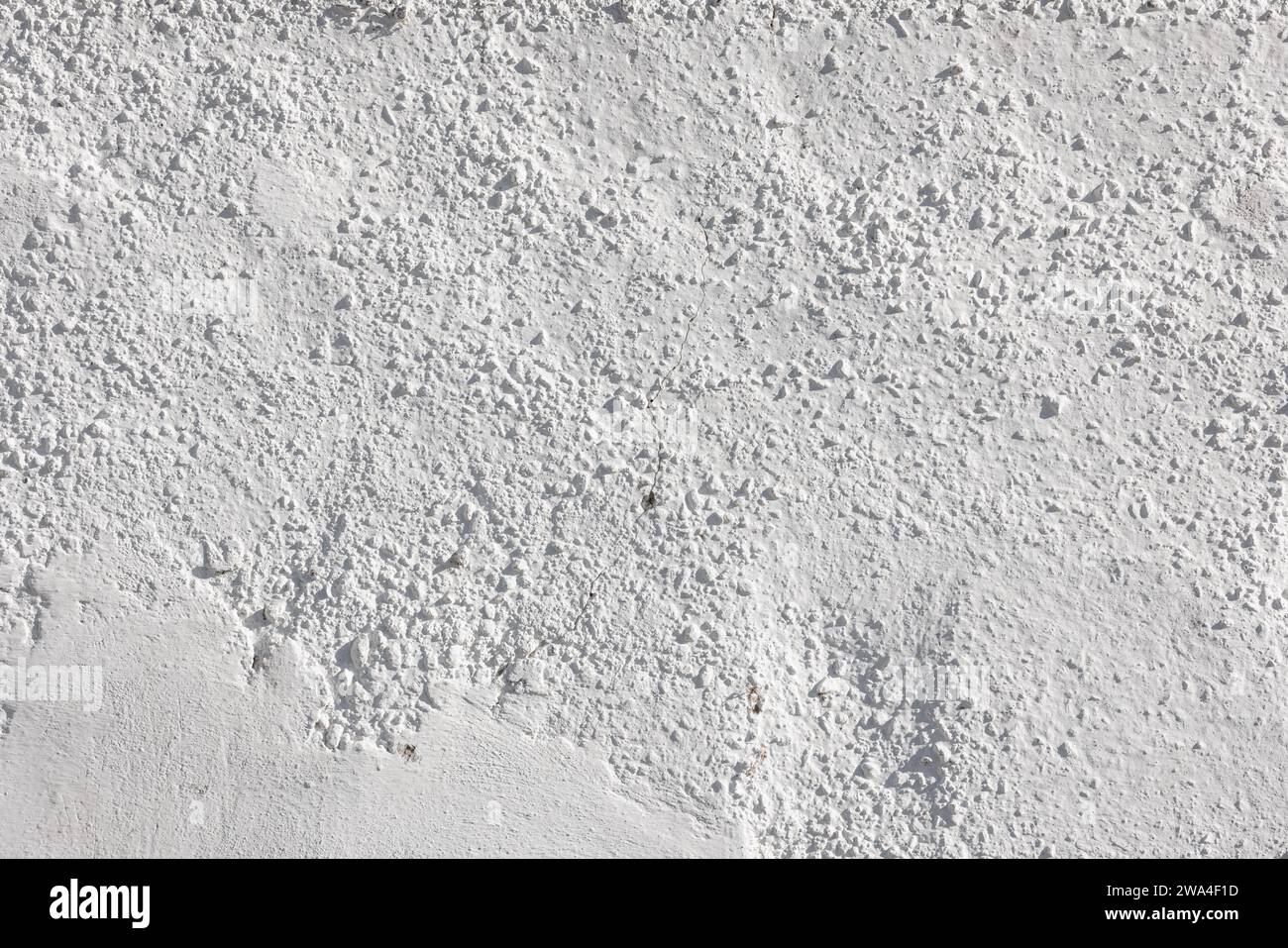 rough whitewash or white plaster wall under direct sunlight, full-frame background and texture Stock Photo