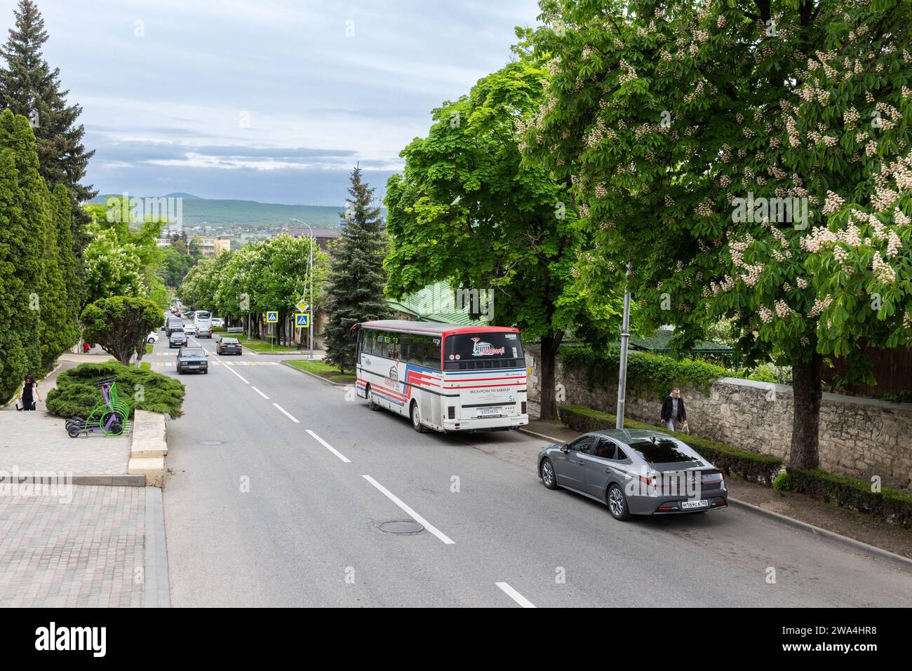 Pyatigorsk, Russia - May 12, 2023: Street view with parked tourist bus, ordinary people walk the street Stock Photo
