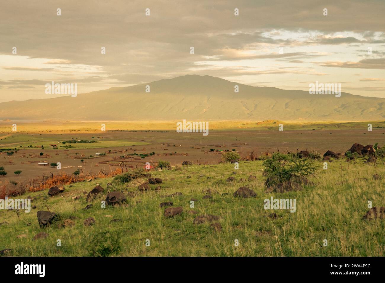 View of masai village against the background of Mount Ol Doinyo Lengai in Ngorongoro Conservationa Area in Tanzania Stock Photo