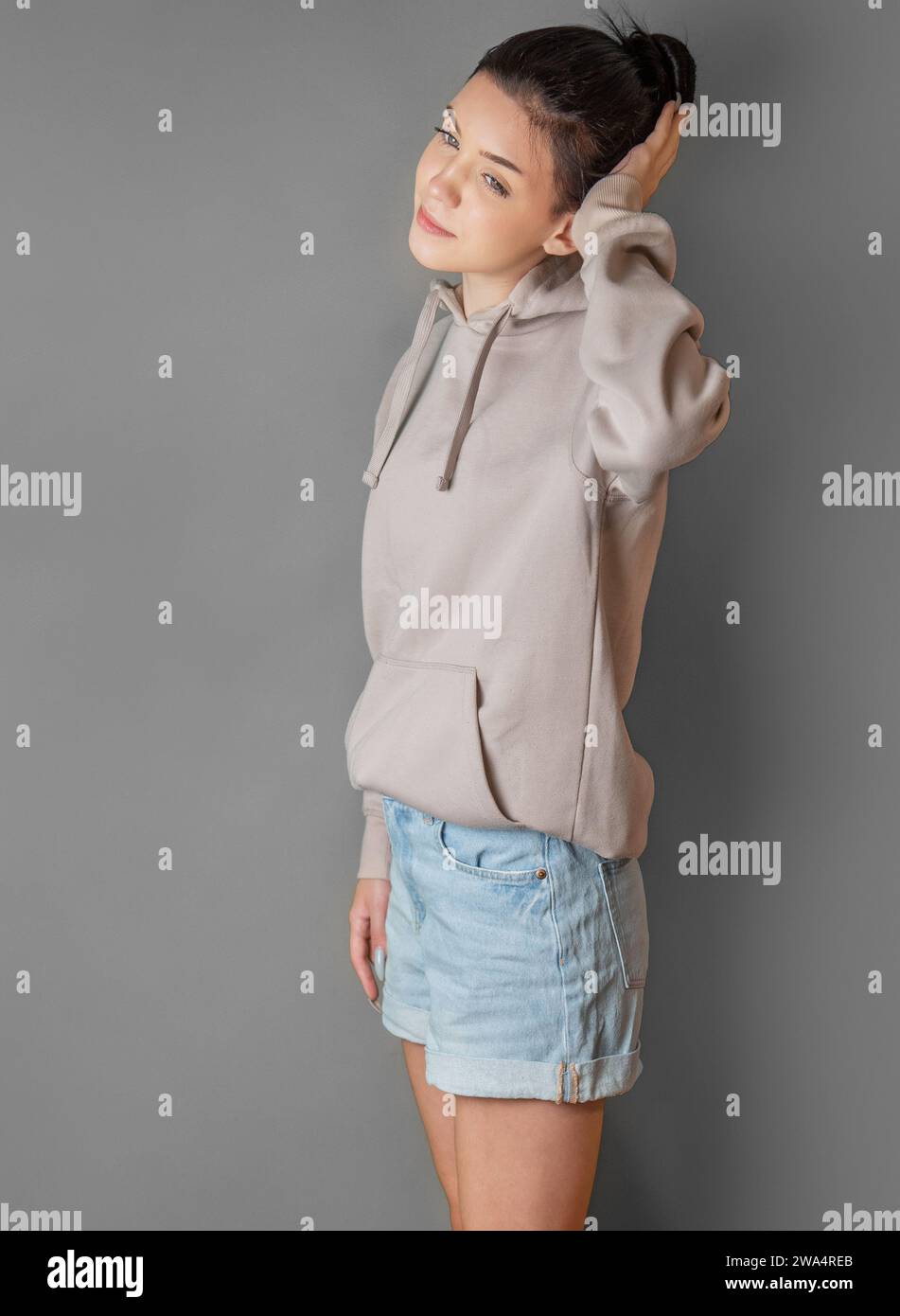 Pensive thoughtful teenager girl wearing sweatshirt with hood Stock Photo