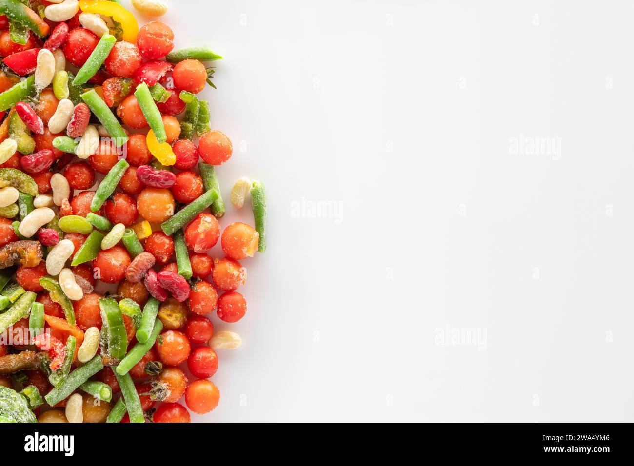 Frozen vegetables on a white background with copy space. Frozen assorted vegetables covered with snow and ice ready to cook. Stock Photo
