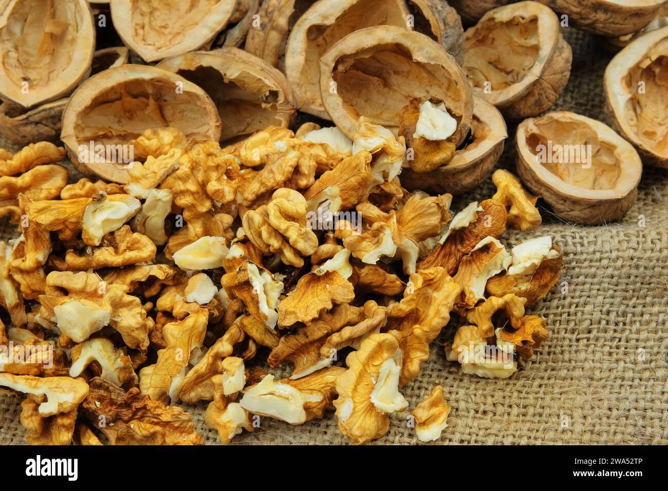Walnuts on old rustic table. Walnut kernels and walnut shell. Vegetarian food. Stock Photo