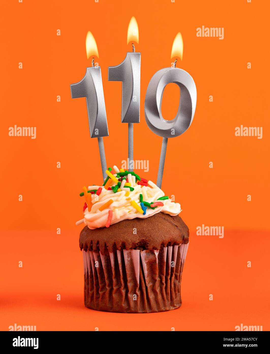 Birthday cupcake with number 110 candle - Orange color background Stock ...