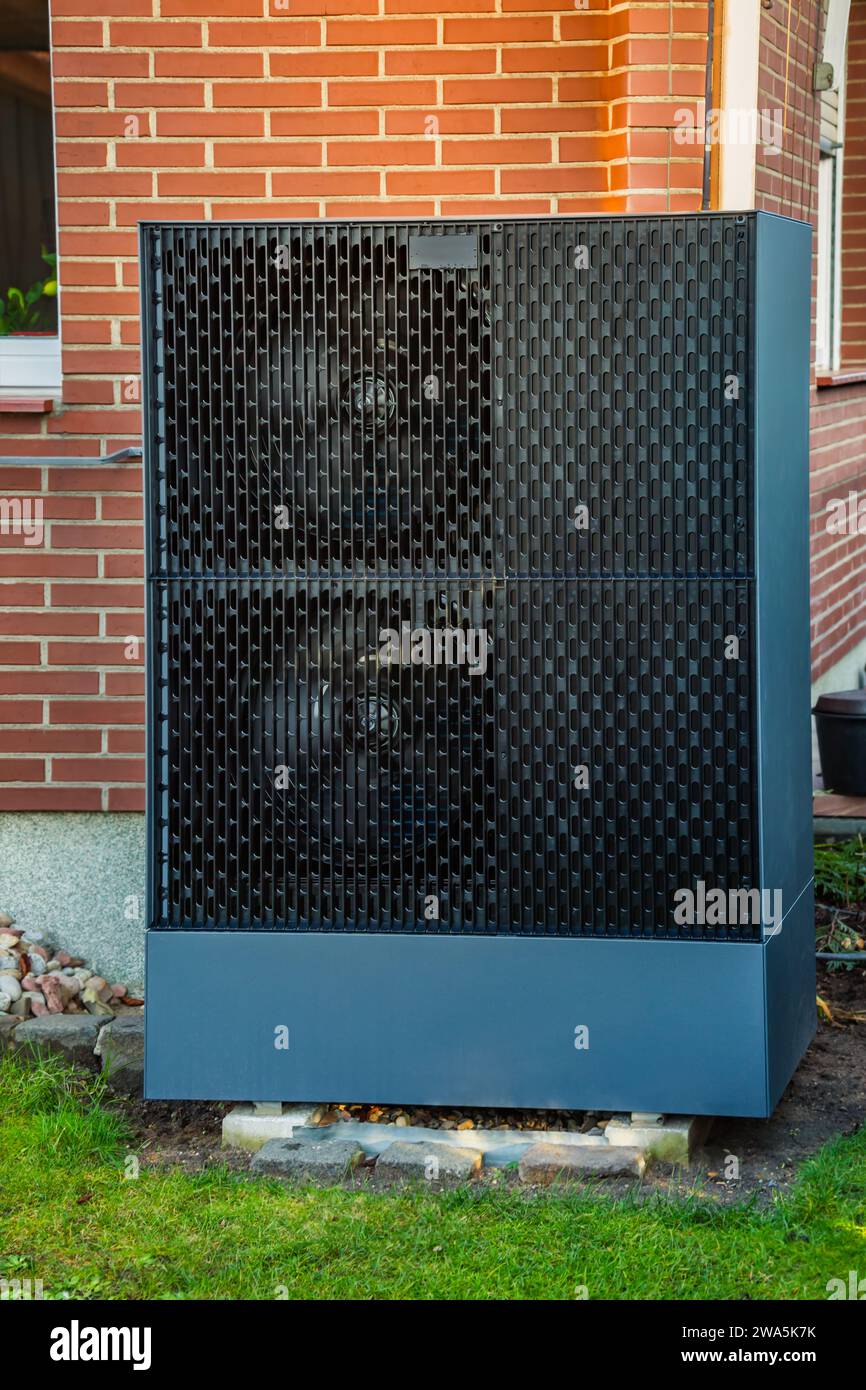 Air source heat pump installed outside in a garden, green renewable energy concept of heat pump Stock Photo