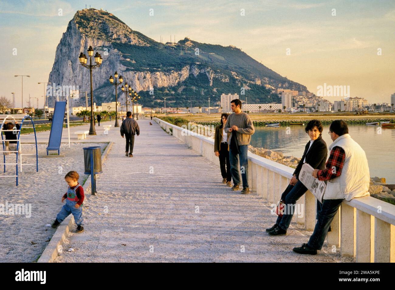 Local people at Avenida de España in La Linea de la Concepcion, Costa del Sol, at Bay of Algeciras, The Rock of Gibraltar in distance, Andalusia Spain Stock Photo
