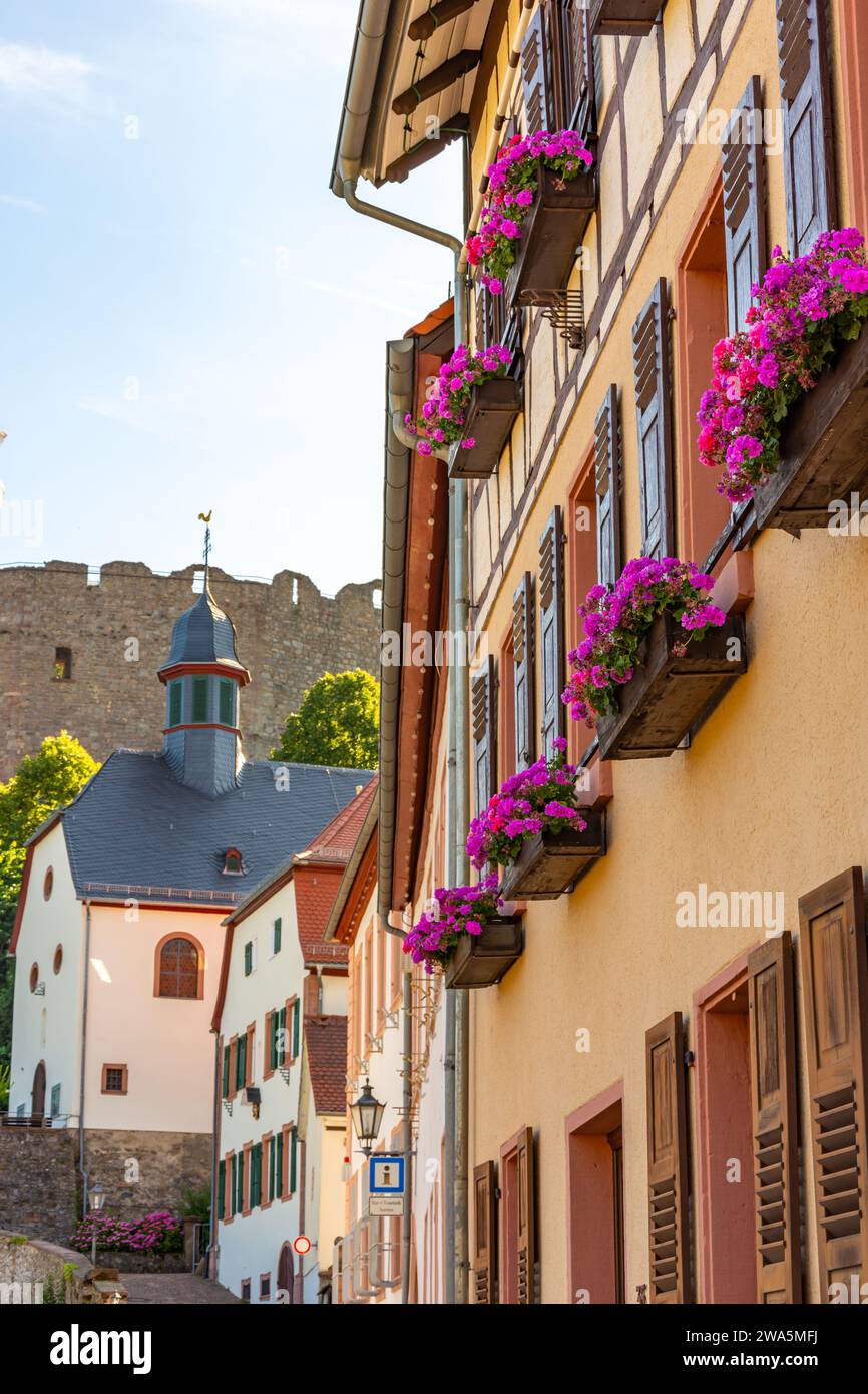 Historic town houses with floral decorations and church at the entrance to Lindenfels Castle in the Odenwald, Germany Stock Photo