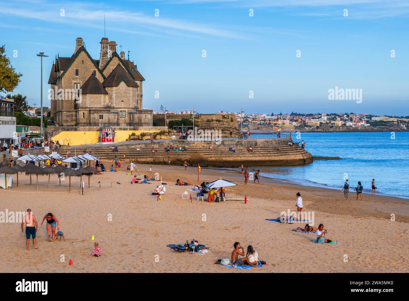 Cascais, Portugal - October 14, 2023 - People on Praia da Duquesa beach and Palmela Palace in resort town by the Atlantic Ocean. Stock Photo
