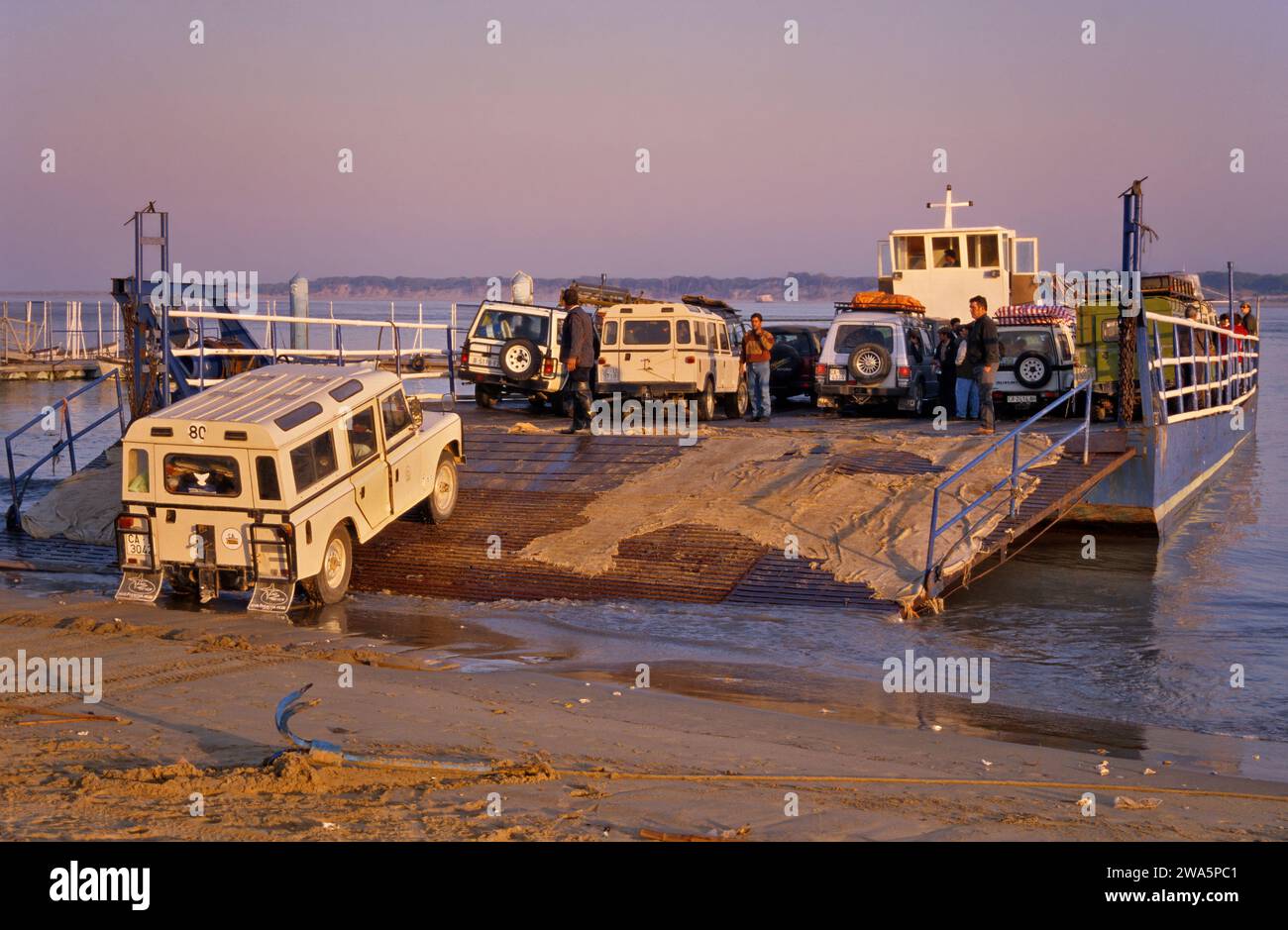 Vehicles loaded at ferry to spend weekend at Coto Doñana Natl Park in Sanlucar de Barrameda at Guadalquivir River, Costa de la Luz, Andalusia, Spain Stock Photo