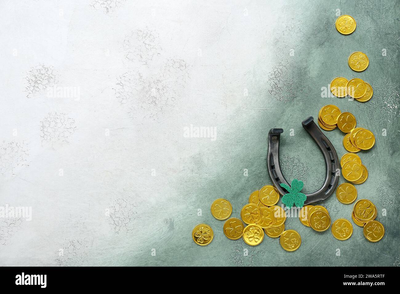 Horseshoe with golden coins and paper clover on green grunge background ...