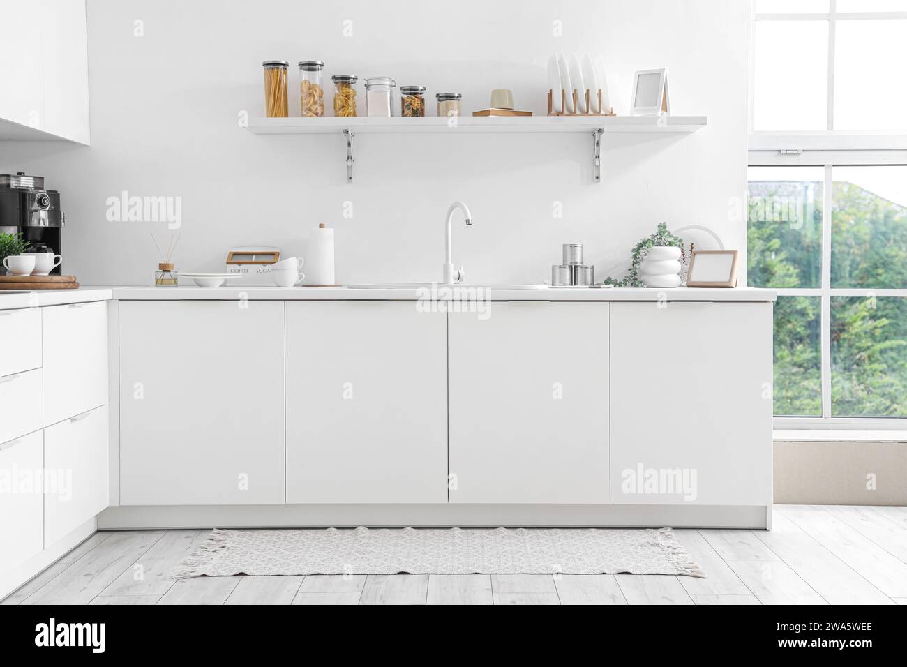 White counters with sink and utensils in interior of modern kitchen ...