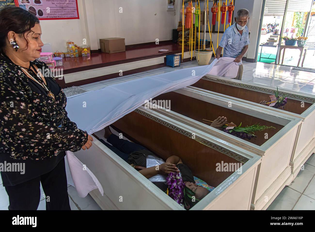 Buddhist devotees lay inside coffins to perform a resurrection ceremony