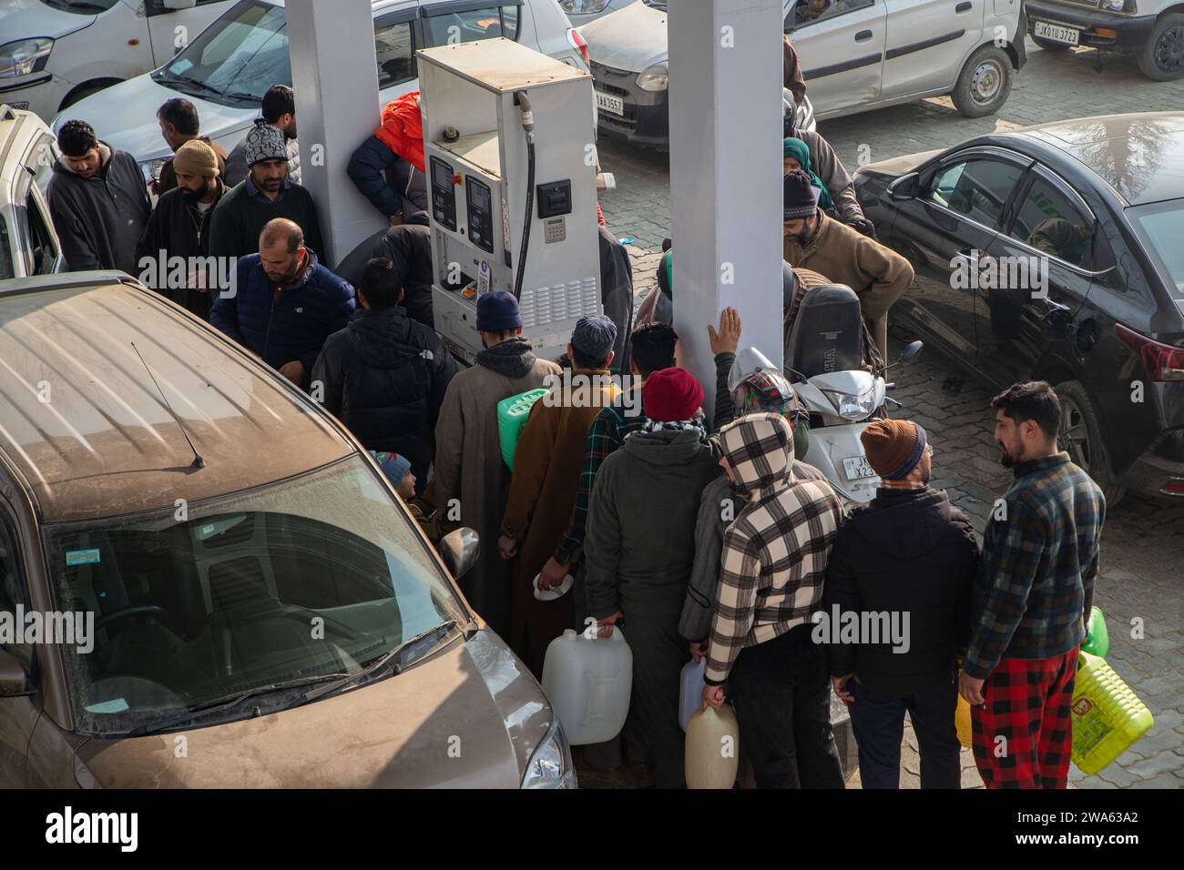 Srinagar, India. 02nd Jan, 2024. People wait in a queue to refill fuel cans at a fuel station. Petrol stations in various Indian states are witnessing long queues as a result of continuous protests by truck and bus drivers across the country against the new panel law on hit-and-run cases. The newly established Bharatiya Nyaya Sanhita law, which repealed the British-era Indian Penal Code, imposes a 10-year prison sentence and a 184.76 US dollars fine for escaping an accident scene and failing to report the incident. (Photo by Faisal Bashir/SOPA Images/Sipa USA) Credit: Sipa USA/Alamy Live News Stock Photo