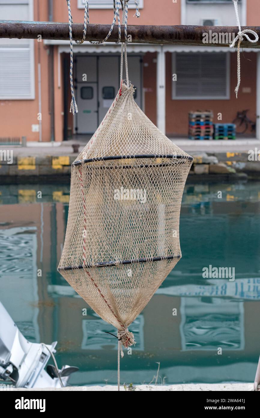 https://c8.alamy.com/comp/2WA641J/items-for-fishing-set-found-on-the-port-of-grado-typical-keepnet-that-is-lowered-into-the-water-and-suspended-at-a-certain-depth-realistic-2WA641J.jpg