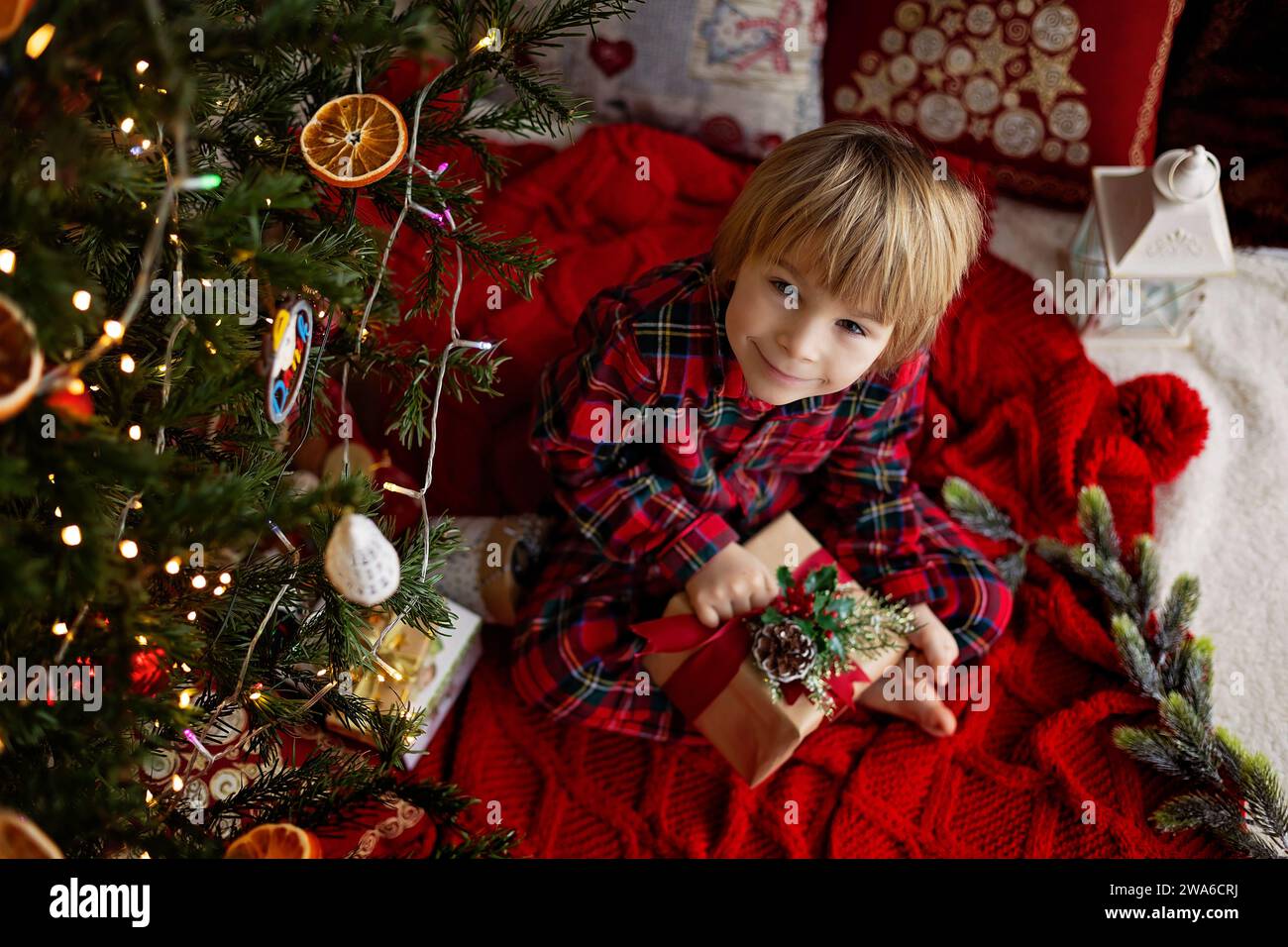 Cute child, cute blond boy, opening presents under the christmas tree Stock Photo