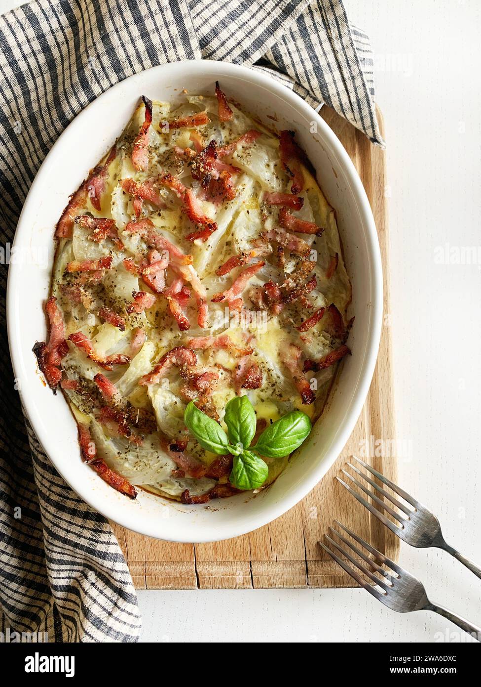 Homemade baked fennel with eggs, cheese and bacon on white background. Overhead view. Copy space