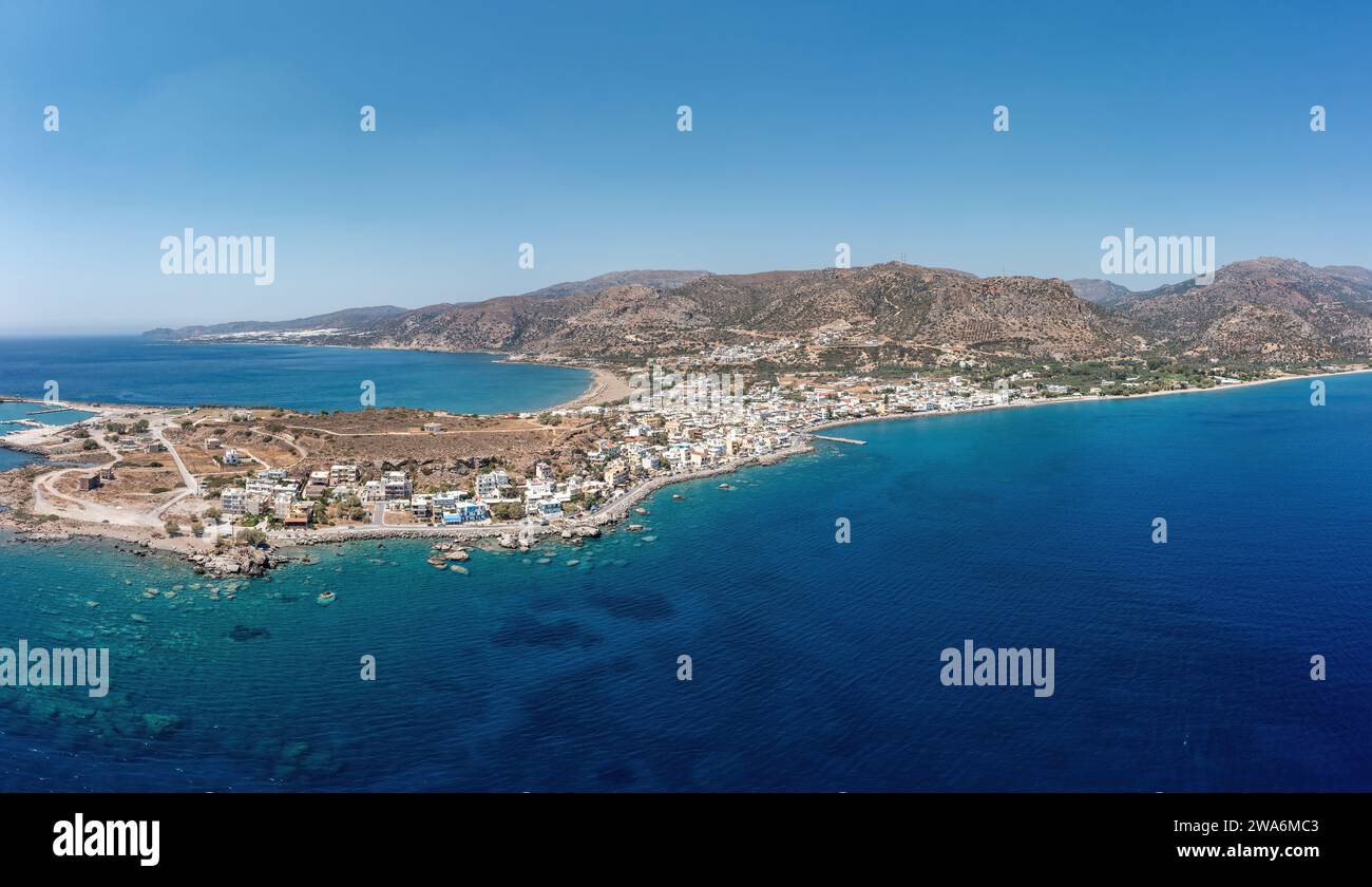 Crete island Palaiochora town, Greece. Aerial drone panoramic view of crystal clear sea water, seaside building, blue sky. Summer destination. Stock Photo