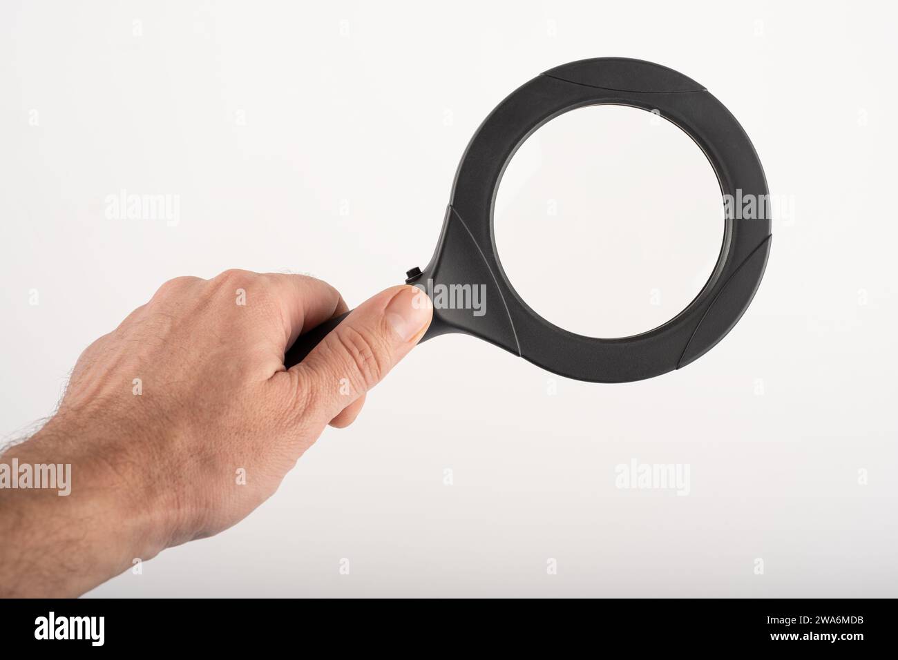 A hand holding a magnifying glass, essence of a searching engine