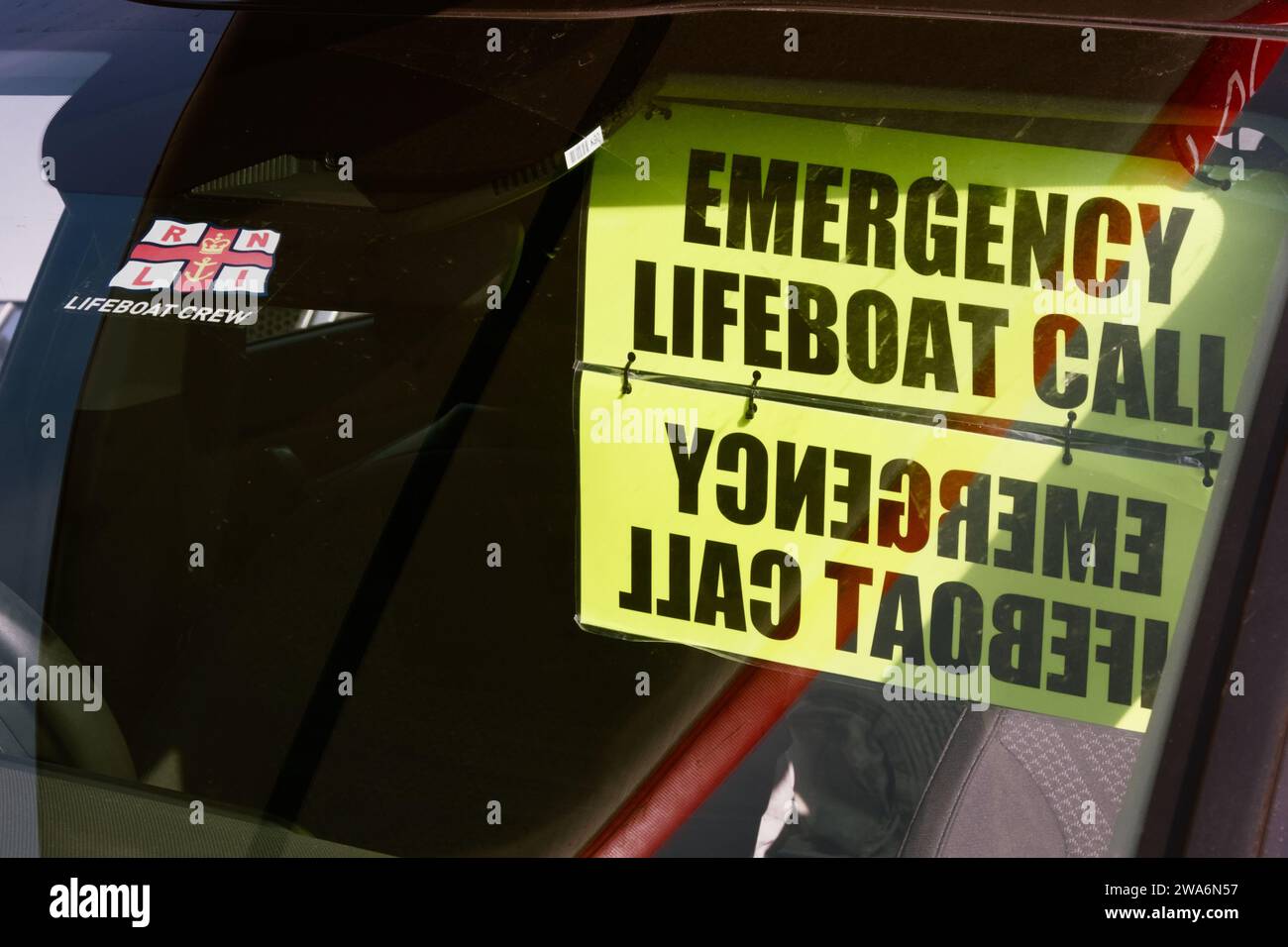 RNLI Lifeboat Crew Windscreen Sticker And Emergency Lifeboat Call Sign Hanging In The Windscreen Of A Car At Mudeford Lifeboat Station Stock Photo