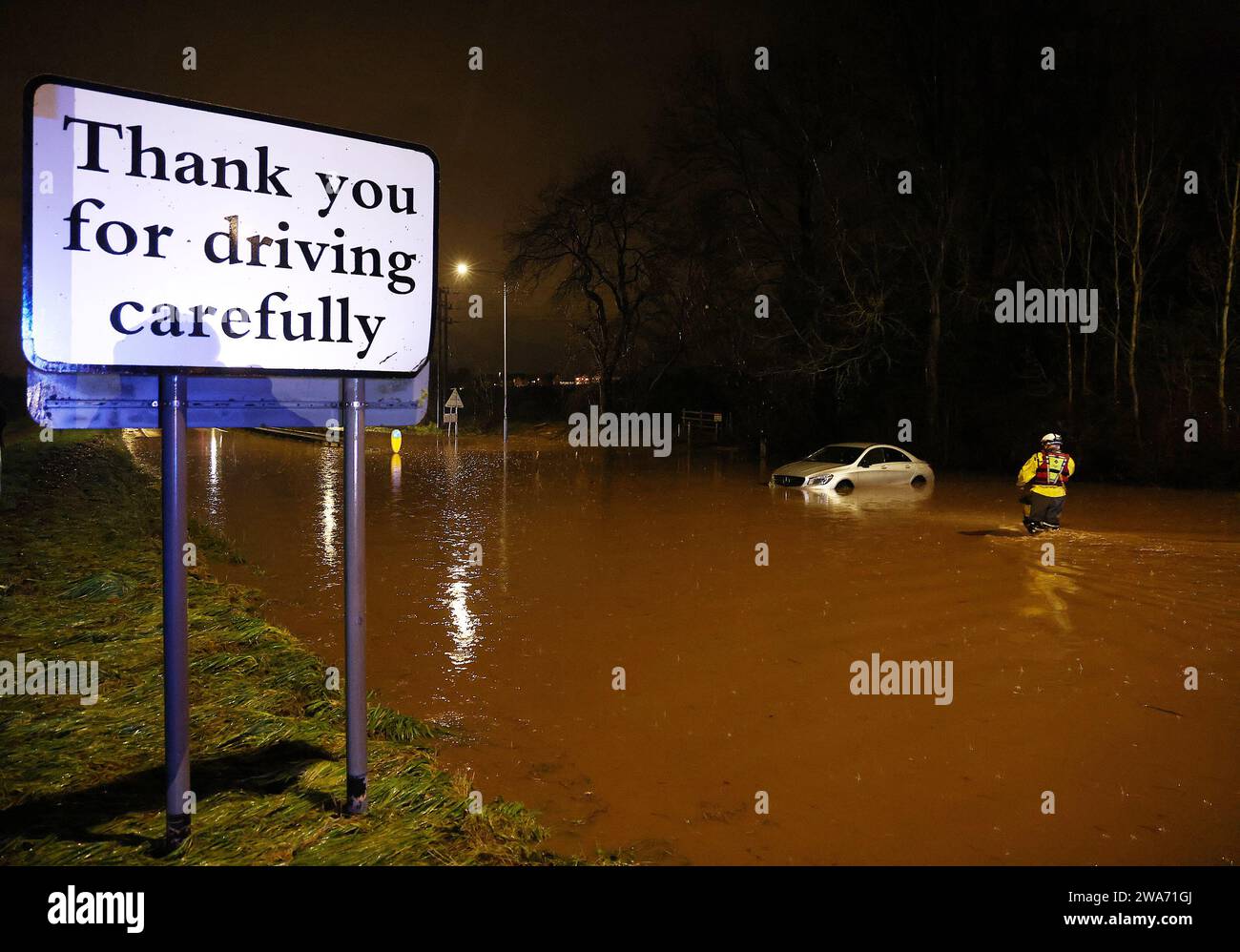 Hathern, Leicestershire, UK. 2nd January 2024. UK weather. A Fire Fighter checks inside a car stranded in flood water. High winds and heavy rain are battering a large swathe of the UK as the small but potent Storm Henk hits.  Credit Darren Staples/Alamy Live News. Stock Photo