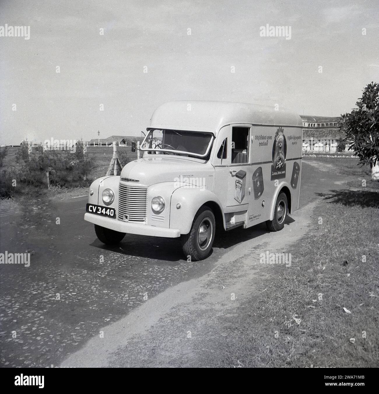 1953, historical, a Commer delivery van on a road in Colombo, Celyon, South Asia. On the side of the van, a smiling baby wearing a crown with the strapline, 'the Food of Royal Babies' and tins of Cow & Gate Milk-Food. Sole Agents: Darley Butler & Co Ltd, Queen St, Colombo. The Cow & Gate 'smiler', a happy, healthy looking baby, first appeared on product packaging & adverts in the 1930s. The 'Royal Baby; with a crown on its head dates back to 1937 and the Coronation of Briitsh King George VI, when the English diary company began to use 'royal association' to endorse their baby milk formula. Stock Photo
