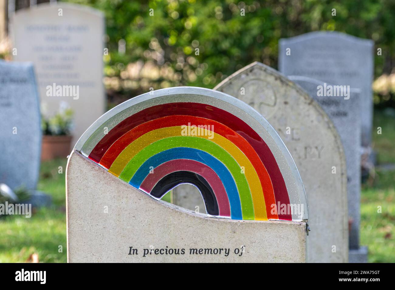 Headstone or gravestone with a LGBTQ pride rainbow on it in a UK cemetery Stock Photo