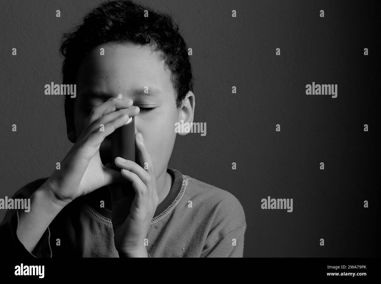 child with flu with inhaler respiratory puff on grey background with people stock photo Stock Photo