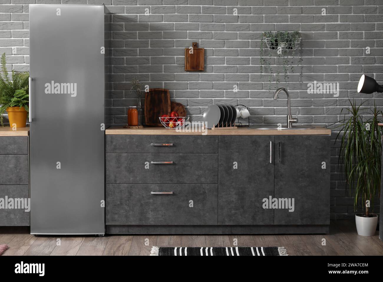 Interior of modern kitchen with grey counters, fridge and houseplants ...