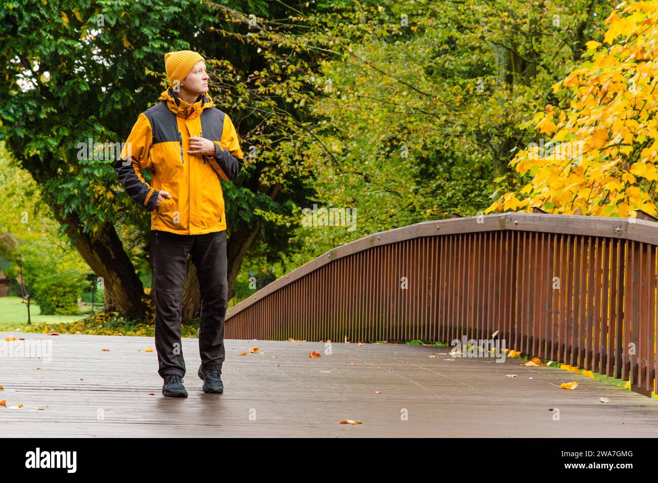 Autumn, bridge and a man in a yellow jacket. Stock Photo