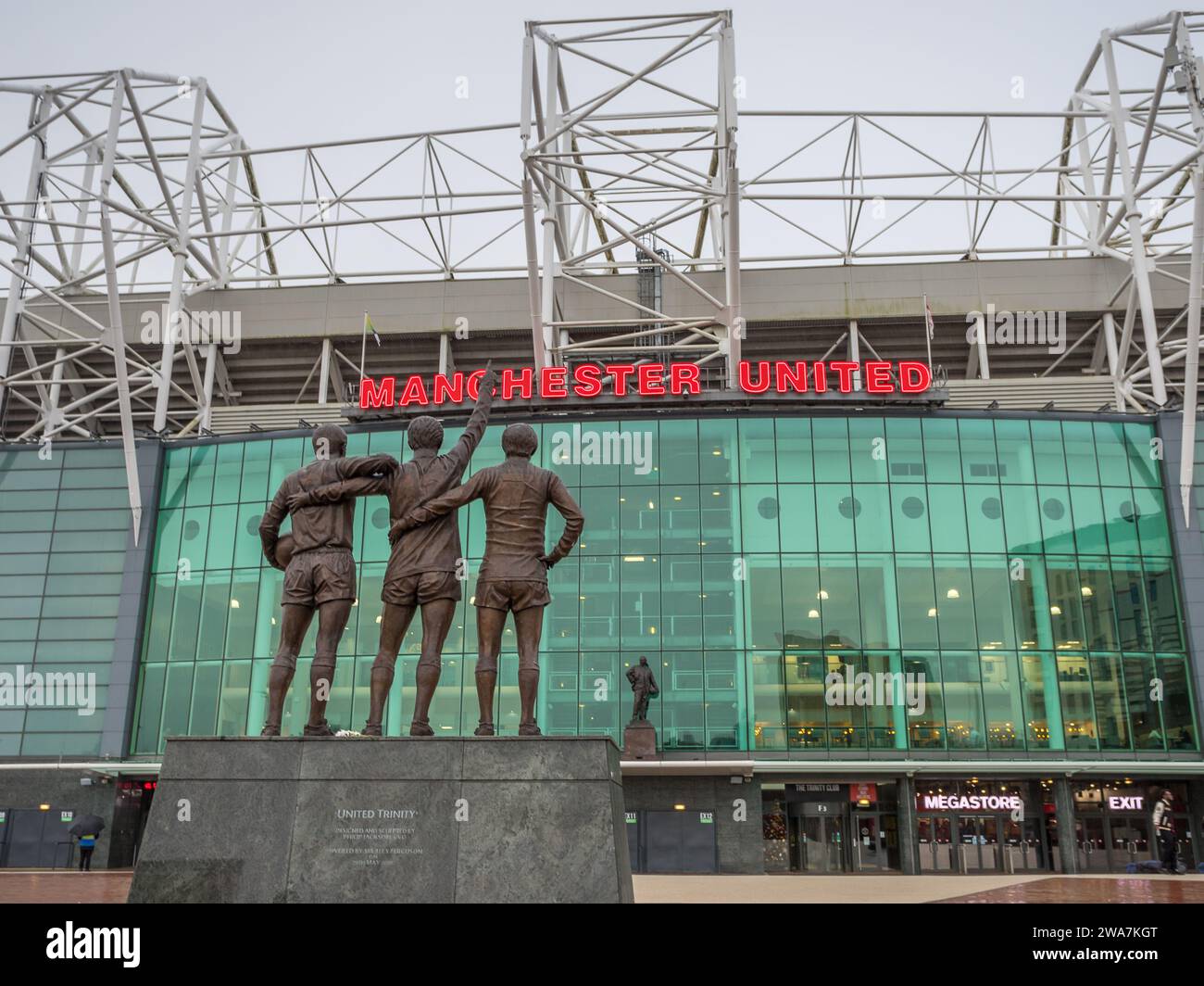 United Trinity statue featuring Manchester United legends George Best, Denis Law and Sir Bobby Charlton pictured facing Old Trafford stadium and the S Stock Photo