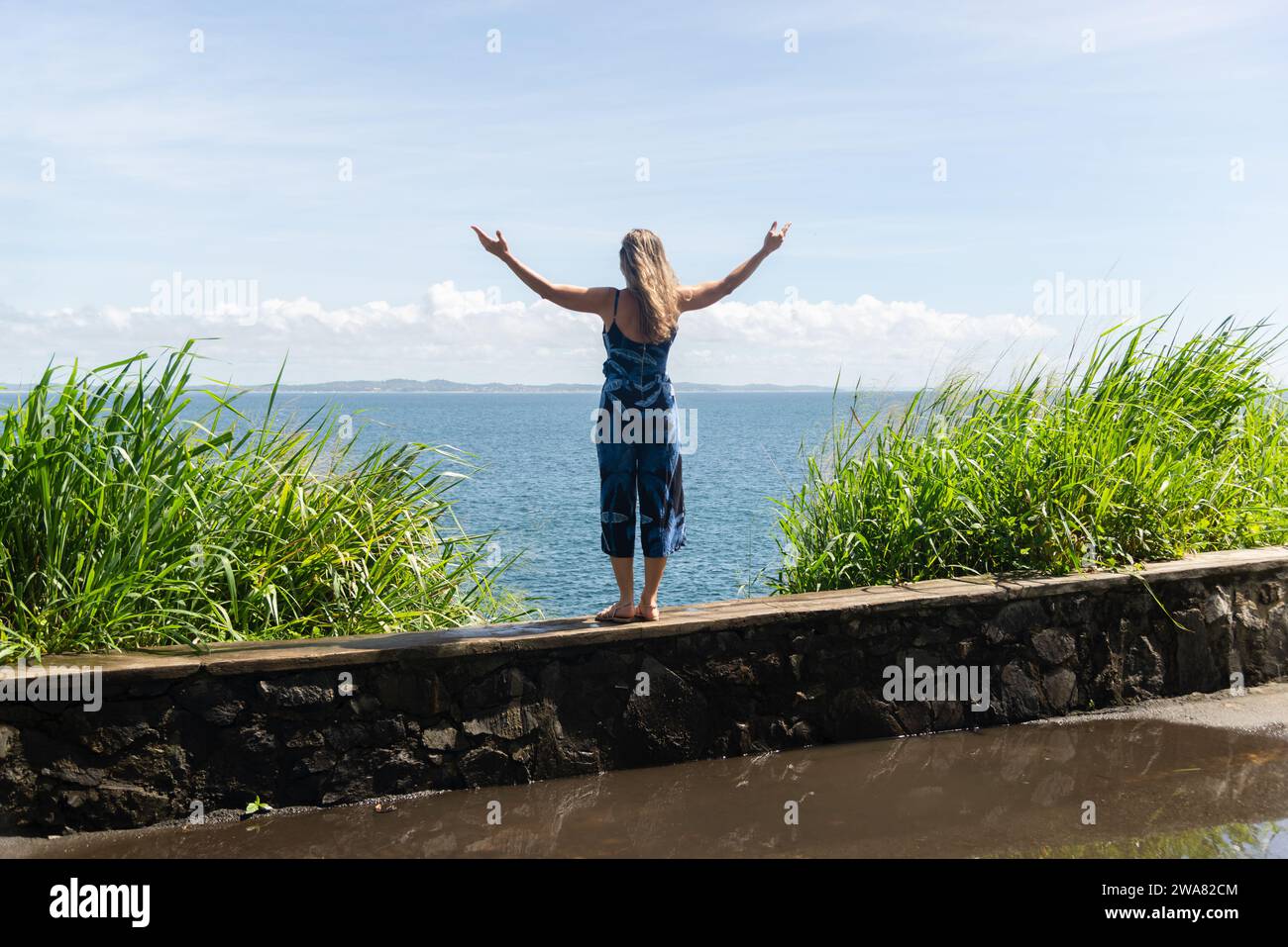 A woman, tourist, standing with her back to the camera with her arms ...
