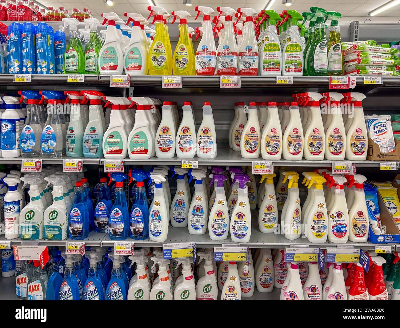 Italy - January 02, 2024: Degreasers and cleaners in plastic spray bottles of various types and brands displayed on shelves for sale in Italian superm Stock Photo