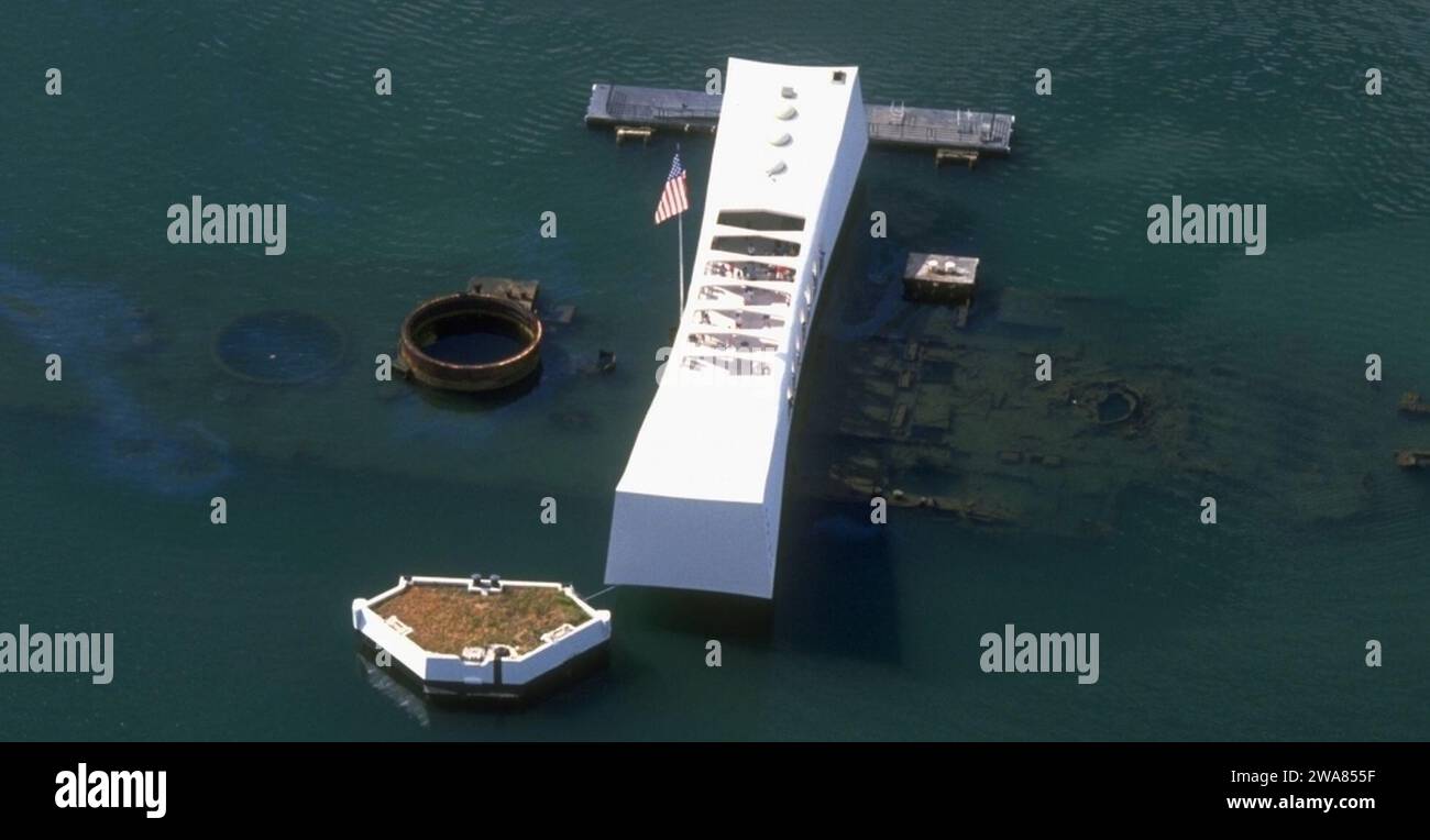 US military forces. The USS Arizona Memorial, dedicated in 1962, straddles the remains of the battleship sunk during the surprise Japanese air attack, Dec. 7, 1941. The memorial pays tribute to the nearly 1,200 sailors and Marines who died aboard the Pennsylvania-class super-dreadnaught during the attack as well as all of the 2,403 military and civilian personnel who perished that Sunday morning. A bomb detonated in her powder magazine caused a violent explosion and immediately sank the craft, Navy hull number BB-39.The more than one million visitors a year to the memorial can see the diesel f Stock Photo