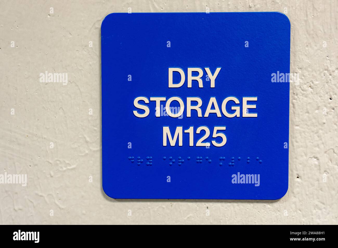 Blue Dry Storage M125 sign with braille, on a white block wall Stock Photo Alamy