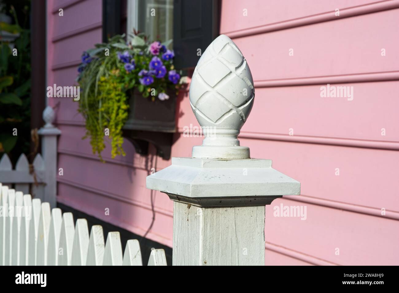 Pinecone topped picket fence post before beaded lap siding colonial home in Charleston South Carolina Stock Photo