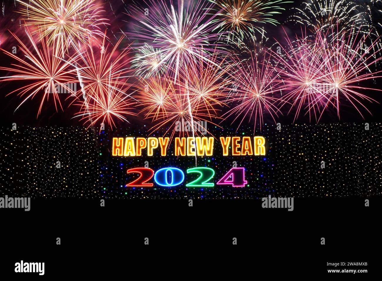 Happy New Year 2024 illuminated sign with firework background Stock Photo