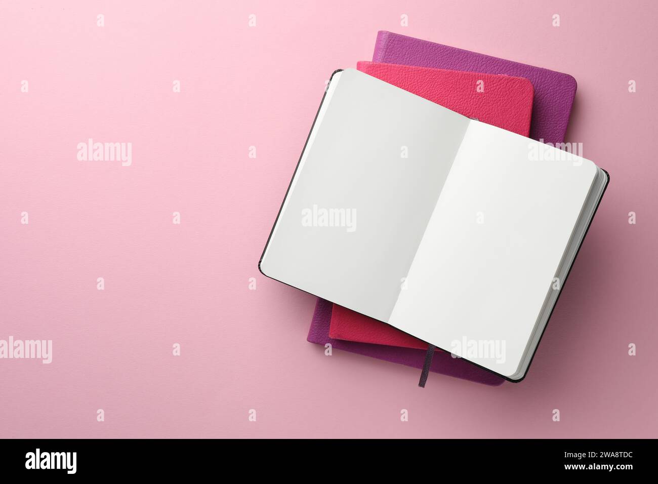 Different notebooks on light pink background, top view. Space for text Stock Photo