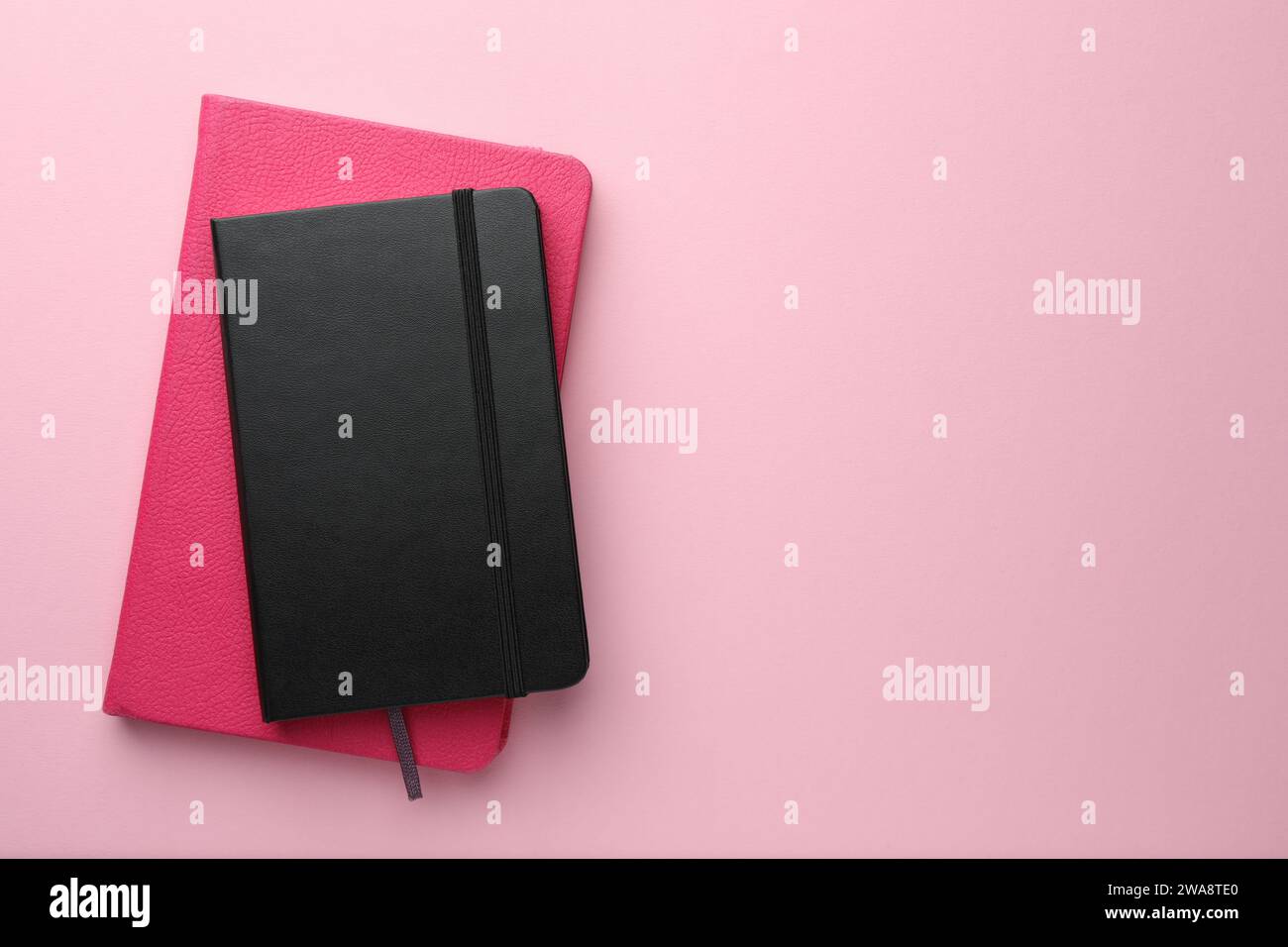 Different notebooks on light pink background, top view. Space for text Stock Photo