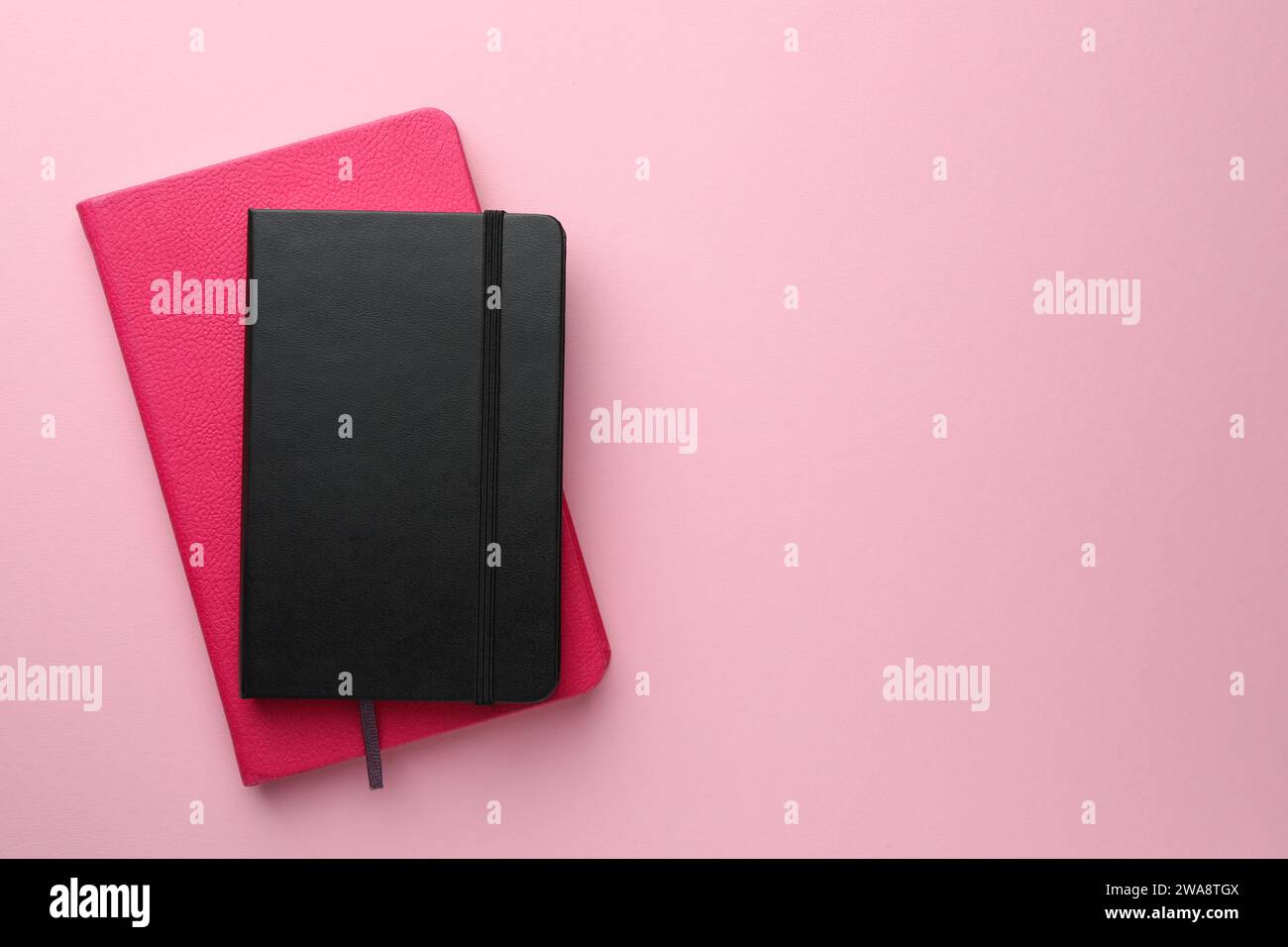 Different notebooks on light pink background, top view. Space for text Stock Photo