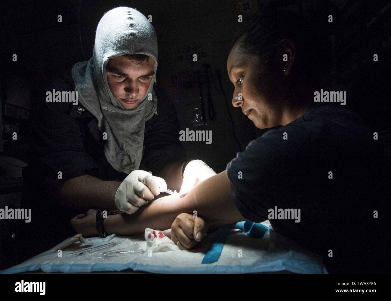 US military forces. 171207KA046-0351  MEDITERRANEAN SEA (Dec. 7, 2017) - Hospital Corpsman 3rd Class Daniel Heaps inserts an intravenous line into the arm of Logistics Specialist 2nd Class Alina Vasquez for medical training during a general quarters drill aboard the Arleigh Burke-class guided-missile destroyer USS Carney (DDG 64), Dec. 7, 2017. Carney, forward-deployed to Rota, Spain, is on its fourth patrol in the U.S. 6th Fleet area of operations in support of regional allies and partners, and U.S. national security interests in Europe. (U.S. Navy photo by Mass Communication Specialist 2nd C Stock Photo