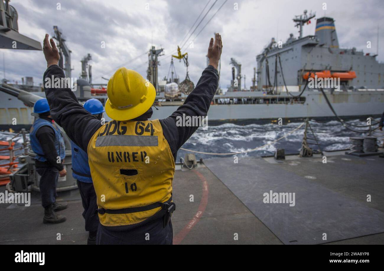 US military forces. 171220KA046-0392  MEDITERRANEAN SEA (Dec 20, 2017) Р Boatswain's Mate 2nd Class Christopher Hampton acts as the rig captain aboard the Arleigh Burke-class guided-missile destroyer USS Carney (DDG 64), during a replenishment-at-sea with USNS Leroy Grumman (T-AO 195), in the Mediterranean Sea, Dec. 20, 2017. Carney, forward-deployed to Rota, Spain, is on its fourth patrol in the U.S. 6th Fleet area of operations in support of regional allies and partners, and U.S. national security interests in Europe. (U.S. Navy photo by Mass Communication Specialist 2nd Class James R. Turne Stock Photo