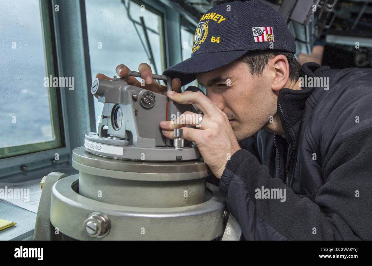 US military forces. 180104KA046-0062  AEGEAN SEA (Jan. 4, 2018) – Ensign Jordan Whittle takes a bearing through a telescopic alidade on the bridge of the Arleigh Burke-class guided-missile destroyer USS Carney (DDG 64) while underway in the Aegean Sea, Jan. 4, 2018. Carney, forward-deployed to Rota, Spain, is on its fourth patrol in the U.S. 6th Fleet area of operations in support of regional allies and partners, and U.S. national security interests in Europe. (U.S. Navy photo by Mass Communication Specialist 2nd Class James R. Turner/Released) Stock Photo