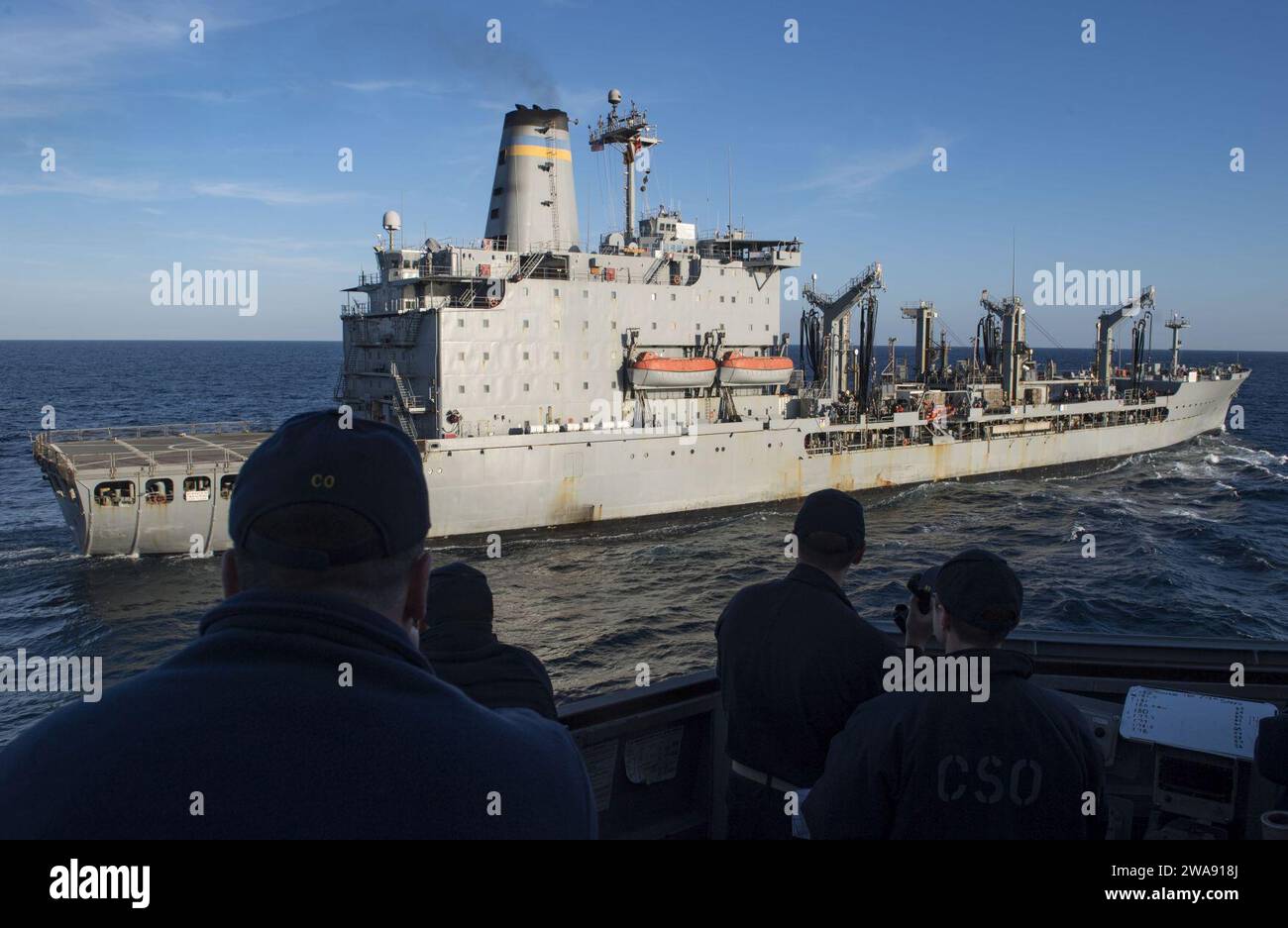US military forces. 180301RG482-145  MEDITERRANEAN SEA (March 1, 2018) Cmdr. Bryan S. Gallo, far left, commanding officer of the Arleigh Burke-class, guided-missile destroyer USS Ross (DDG 71), watches as Ross comes alongside the Henry J. Kaiser-class underway replenishment oiler USNS Patuxent (T-AO-201) during a replenishment at sea March 1, 2018. Ross, forward-deployed to Rota, Spain, is on its sixth patrol in the U.S. 6th Fleet area of operations in support of regional allies and partners and U.S. national security interests in Europe. (U.S. Navy photo by Mass Communication Specialist 1st C Stock Photo