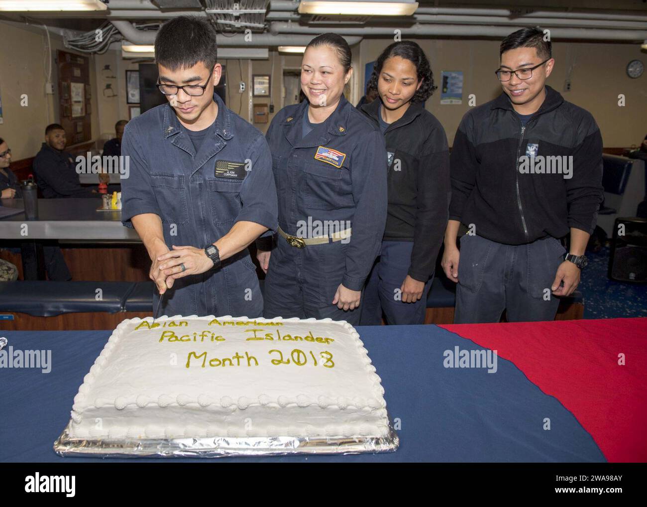 US military forces. 180527PC620-0020  NORTH SEA (May 27, 2018) Hospital Corpsman 2nd Class Andy Kim cuts a cake during an Asian American and Pacific Islander Heritage Month celebration on the mess decks of the Harpers Ferry-class dock landing ship USS Oak Hill (LSD 51) May 27, 2018. Oak Hill, homeported in Virginia Beach, Virginia, is conducting naval operations in the U.S. 6th Fleet area of operations. (U.S. Navy photo by Mass Communication Specialist 3rd Class Michael H. Lehman/Released) Stock Photo
