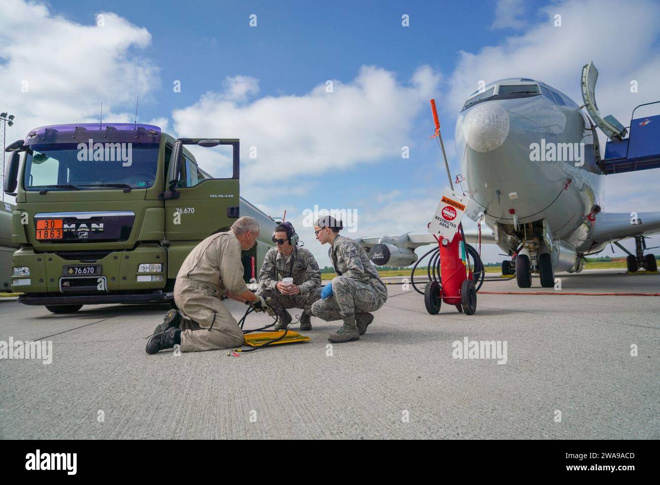 US military forces. Flight Specialist Jan Pedersen, left, a flight mechanic with Fighter Wing Skrydstrup, assists U.S. Air Force Staff Sgt. Landon Burgess, center, and Senior Airman Morgan Revels, both crew chiefs with the 461st Air Control Wing (ACW), Robins Air Force Base, Georgia, during a refueling operation on an E-8C Joint STARS at Fighter Wing Skrydstrup, Denmark, June 4, 2018. The teamwork demonstrates the interoperability among our units in Europe and cements our ability to assure our allies, respond to threats and ensure support to global operations. The JSTARS team consists of the G Stock Photo