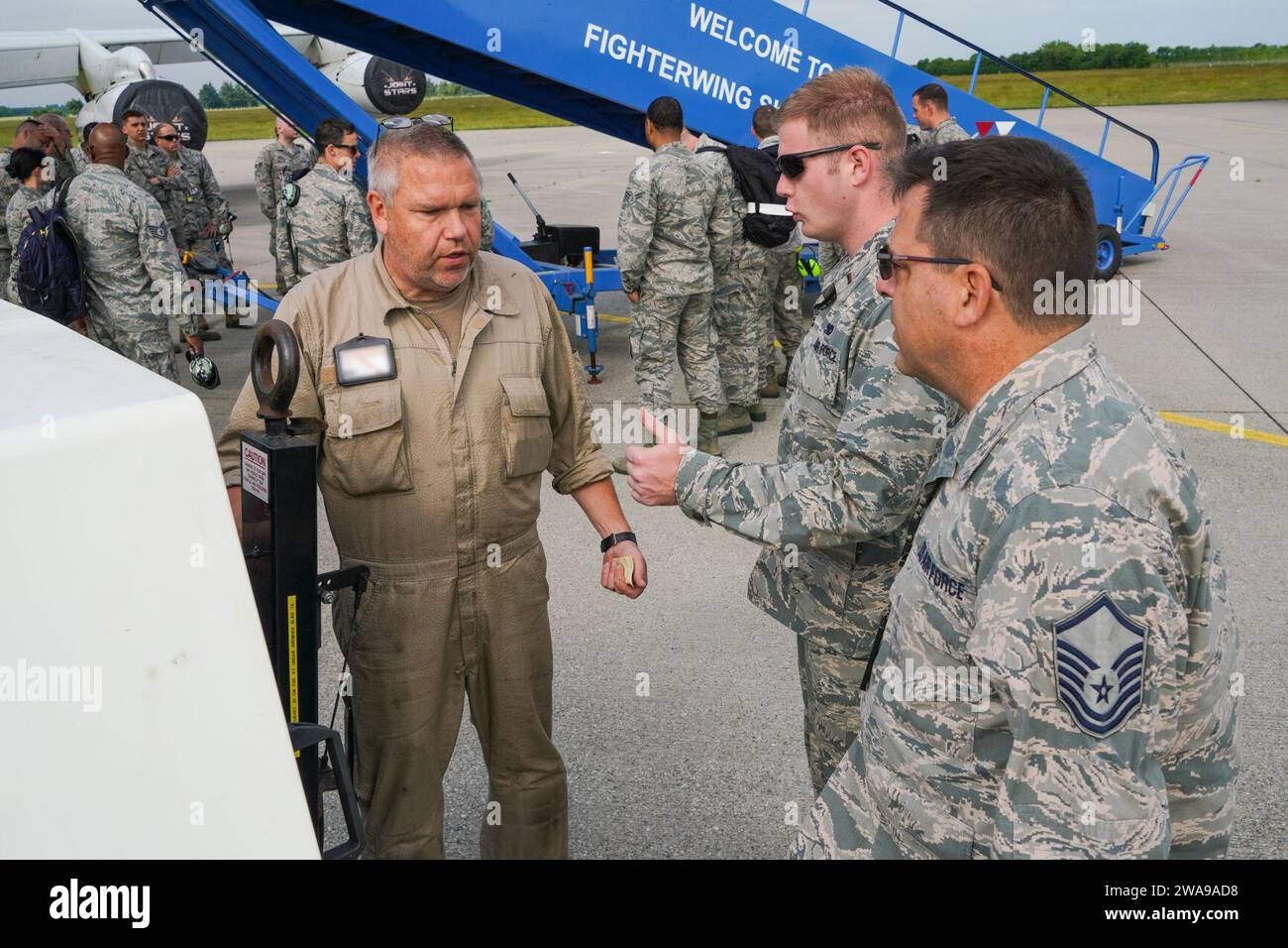 US military forces. U.S. Air Force 2nd Lt. Zachary Knauss, center, aircraft maintenance officer-in-charge with the 461st Air Control Wing (ACW), and Master Sgt. John Rosbury, right, with 116th ACW, Georgia Air National Guard, both from Robins Air Force Base, Georgia, discuss the operation of an aircraft power unit being used to supply power to an E-8C Joint STARS with Flight Specialist Jan Pedersen from Fighter Wing Skrydstrup, Denmark, June 4, 2018. The teamwork demonstrates the interoperability among our units in Europe and cements our ability to assure our allies, respond to threats and ens Stock Photo