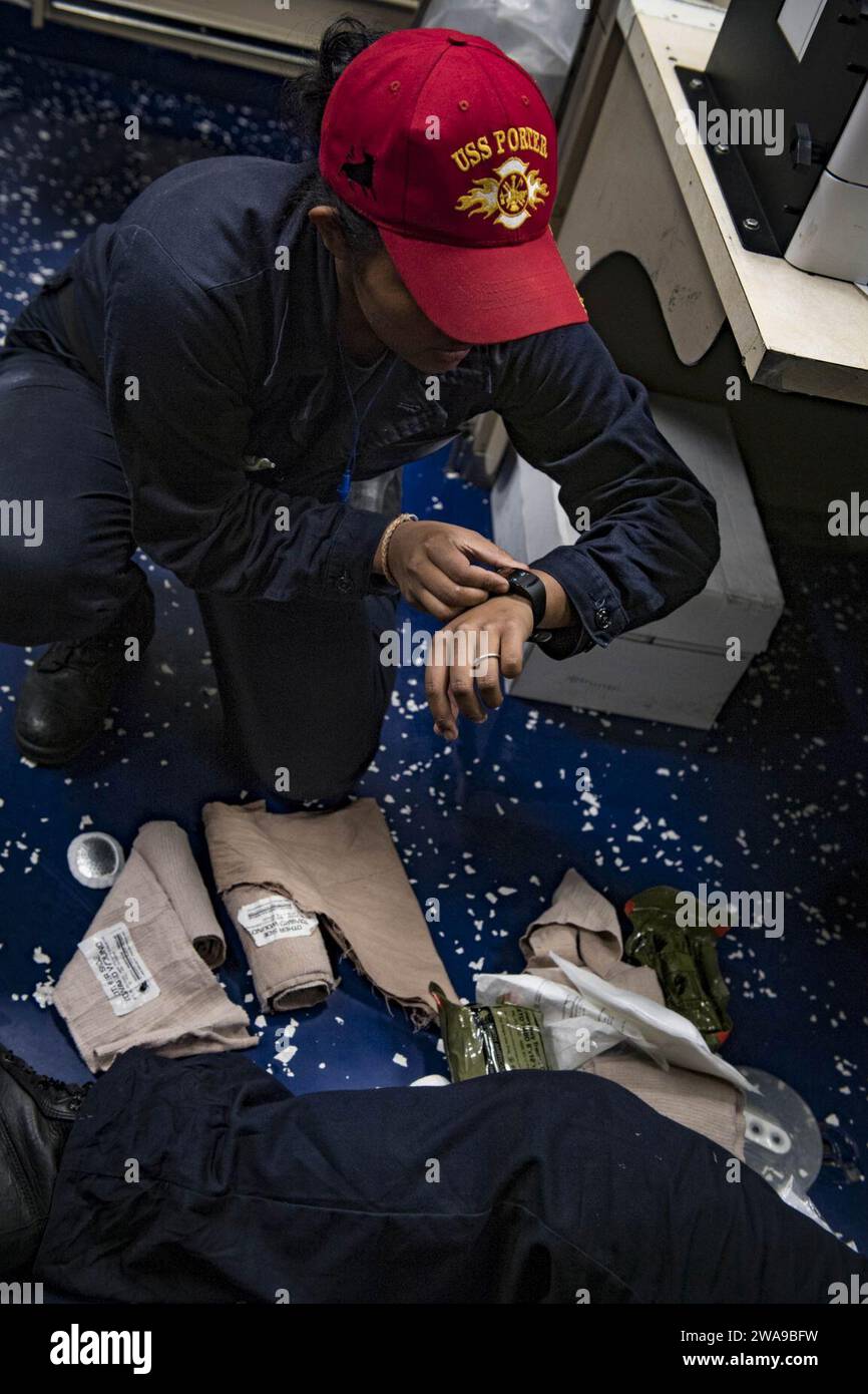 US military forces. 180611JI086-210 MEDITERRANEAN SEA (June 11, 2018) Hull Maintenance Technician Fireman Amberlynn Tan, assigned to the Arleigh Burke-class guided-missile destroyer USS Porter (DDG 78), marks the time during medical training team drills, June 11, 2018. Porter, forward-deployed to Rota, Spain, is on its fifth patrol in the U.S. 6th Fleet area of operations in support of U.S. national security interests in Europe and Africa. (U.S. Navy photo by Mass Communication Specialist 2nd Class Ford Williams/Released) Stock Photo