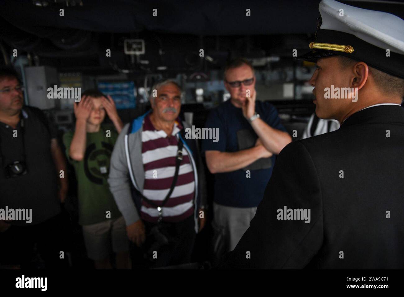 US military forces. 180616FP878-044 KIEL, Germany (June 16, 2018) Lt. Austin Chien, from Naperville, Illinois, gives a tour of the Arleigh Burke-class guided-missile destroyer USS Bainbridge (DDG 96) while in Kiel, Germany, during Kiel Week 2018, June 16. U.S. Naval Forces Europe-Africa/U.S. 6th Fleet, headquartered in Naples, Italy, conducts the full spectrum of joint and naval operations, often in concert will allied and interagency partners, in order to advance U.S. national interests and security and stability in Europe and Africa. (U.S. Navy photo by Mass Communication Specialist 1st Clas Stock Photo