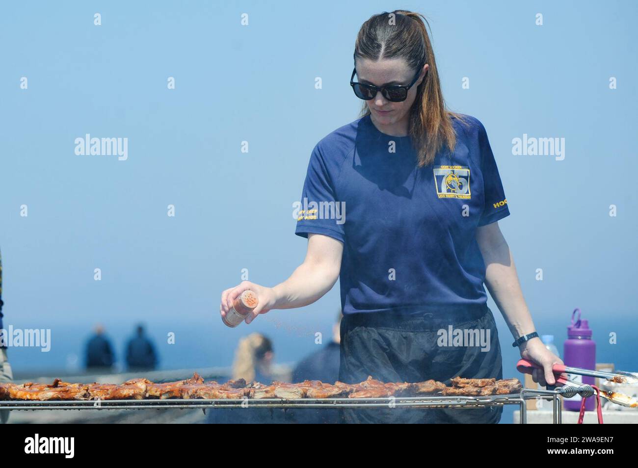 US military forces. 180708UJ486-0533 ATLANTIC OCEAN (July 8, 2018) Master-at-Arms Caitlin Swenson grills during a steel beach picnic aboard the Nimitz-class aircraft carrier USS Harry S. Truman (CVN 75). Harry S. Truman is currently deployed as part of an ongoing rotation of U.S. forces supporting maritime security operations in international waters around the globe. (U.S. Navy photo by Mass Communication Specialist 3rd Class Rebekah A. Watkins/Released) Stock Photo